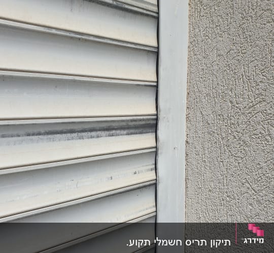 תריס מתכת אפור עם סימני שחיקה